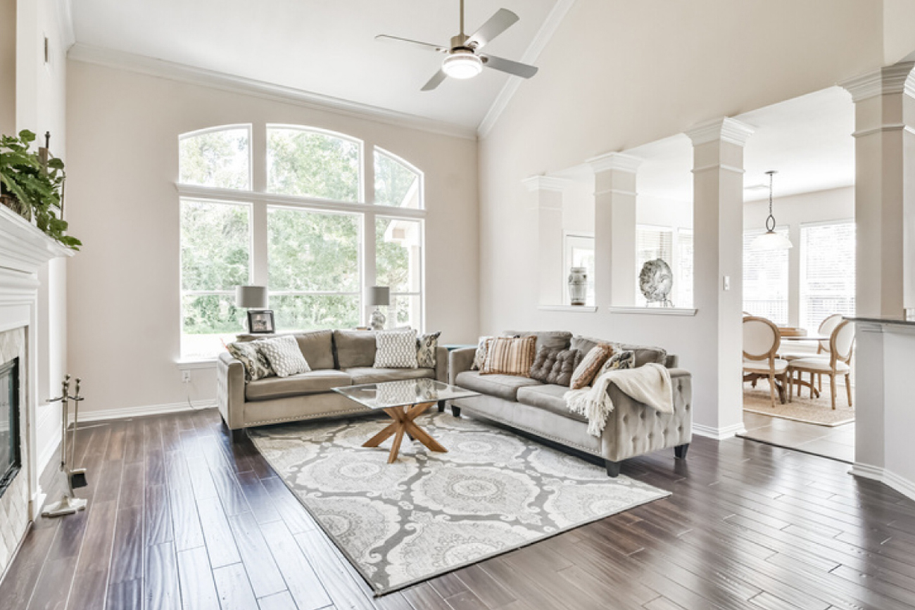 Spacious living room featuring modern furnishings, large windows with natural light, and a cozy atmosphere, ideal for showcasing rural properties in Austin County, Texas.