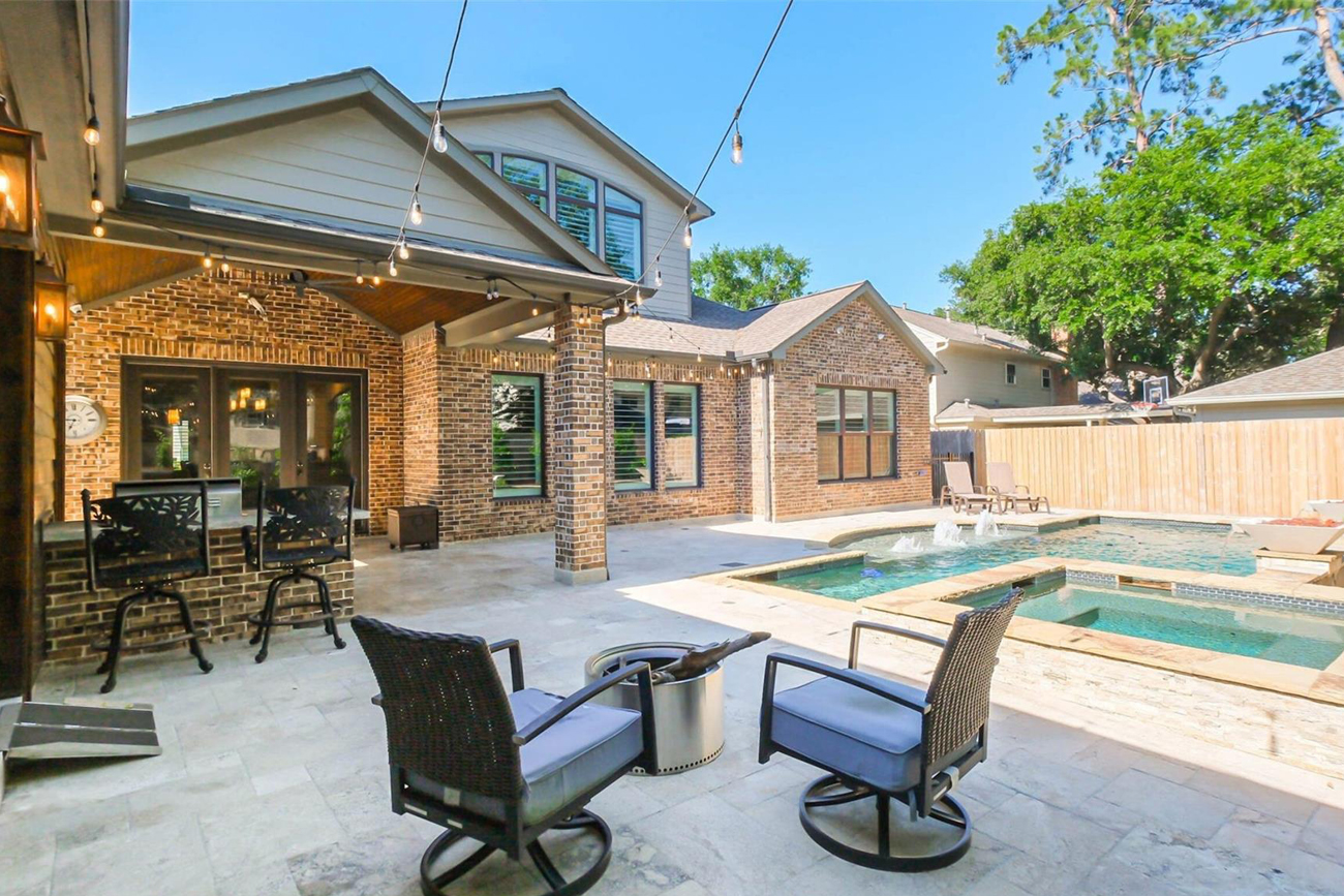 Backyard patio with modern design, featuring a swimming pool, spa, and comfortable seating area, ideal for Texas outdoor living and entertaining.