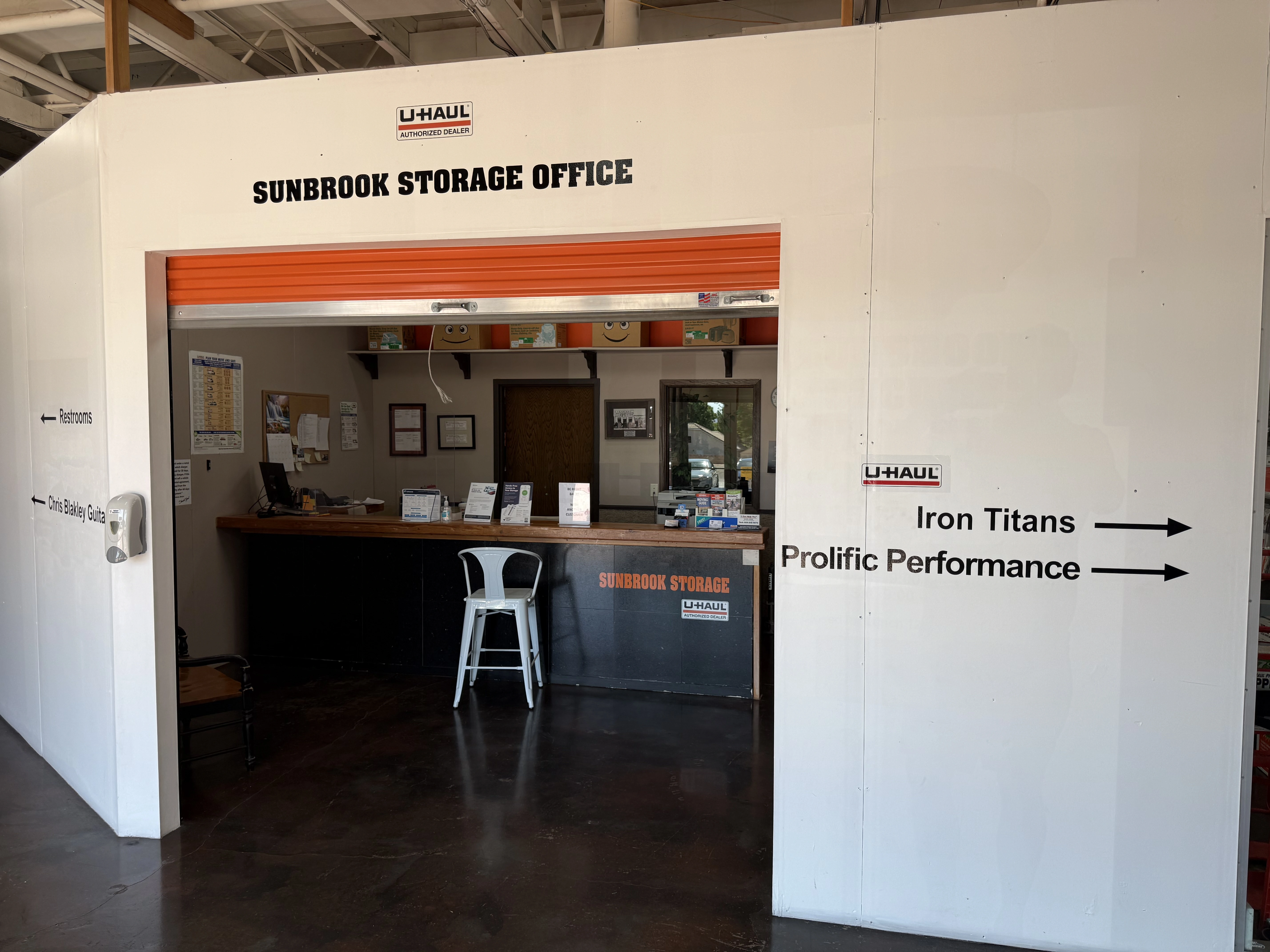Sunbrook Storage Office in St. George, Utah showing front desk, orange roll-up door, U-Haul authorized dealer sign, and professional customer service area
