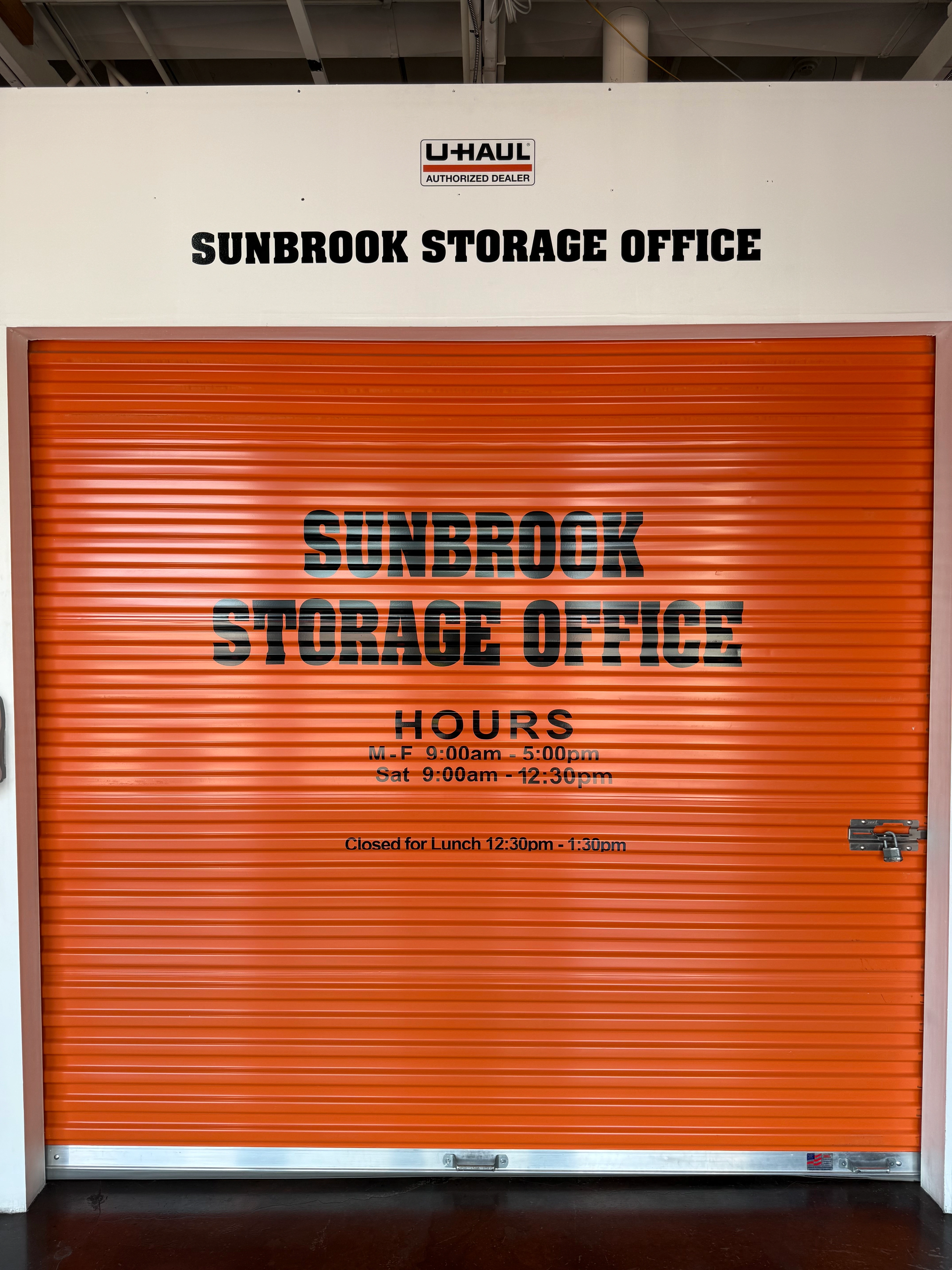 Sunbrook Storage Office in St. George, Utah with orange roll-up door, office hours, and U-Haul authorized dealer sign