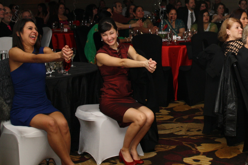 Guests laughing and enjoying Scott Christie's comedy hypnosis show at a Vancouver corporate holiday party