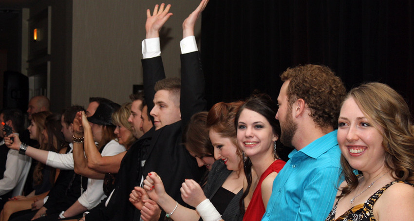 Excited corporate event audience laughing and participating in Scott Christie's comedy hypnosis show in Vancouver