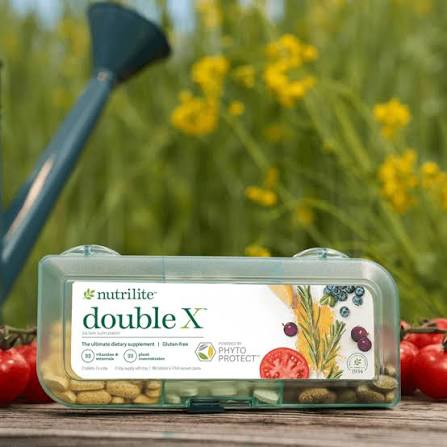 Nutrilite Double X multivitamin pill case on a wooden table outdoors