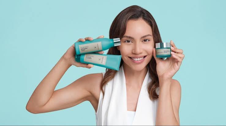 Woman holding Artistry Renewing skincare products