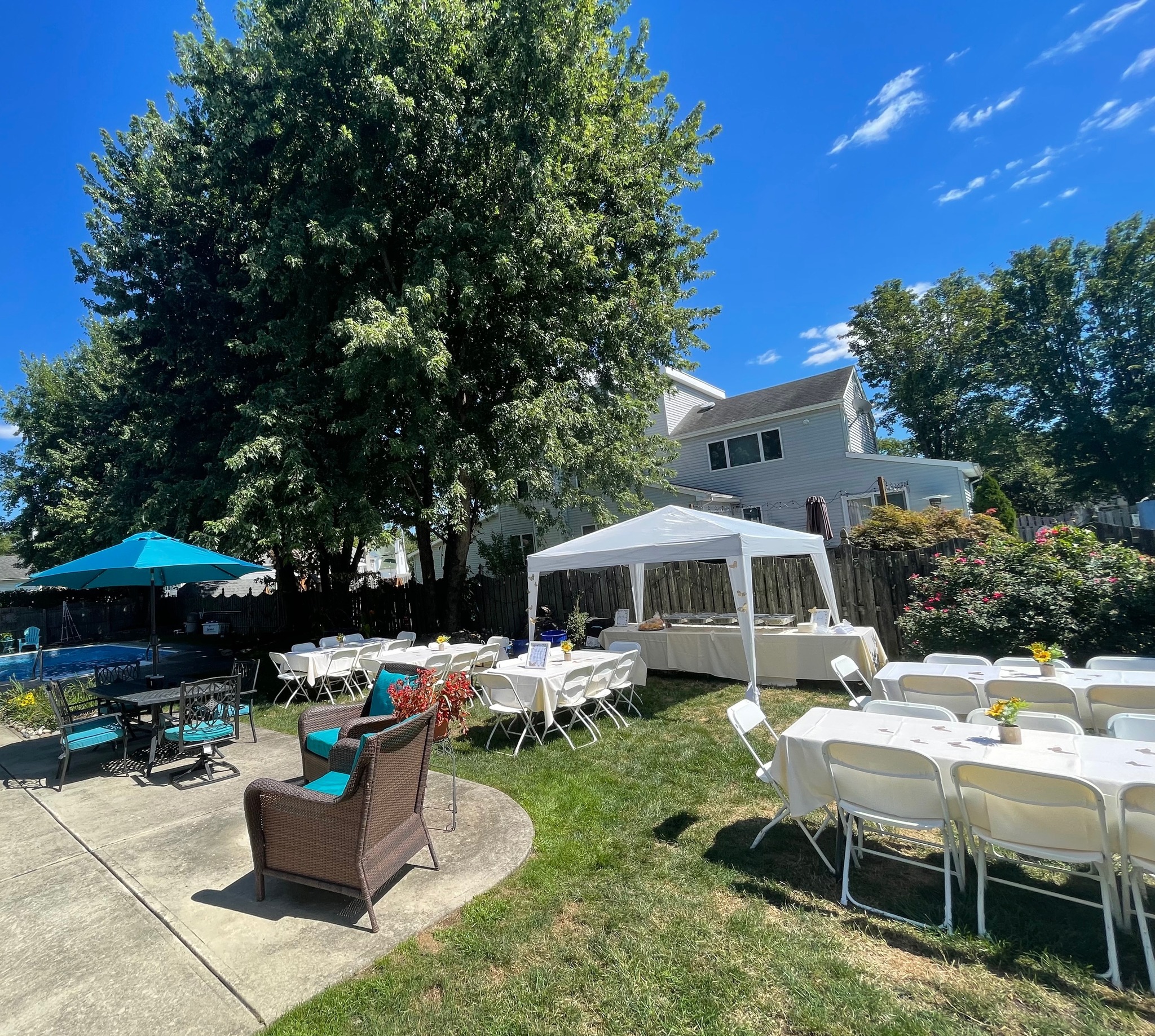 White folding chairs and tables set up under a tent for an outdoor event in Lancaster PA