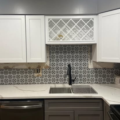 Kitchen Backsplash & Cabinet Refresh - Kitchen with white upper shaker cabinets, patterned black and white encaustic-style backsplash tile, white quartz countertop