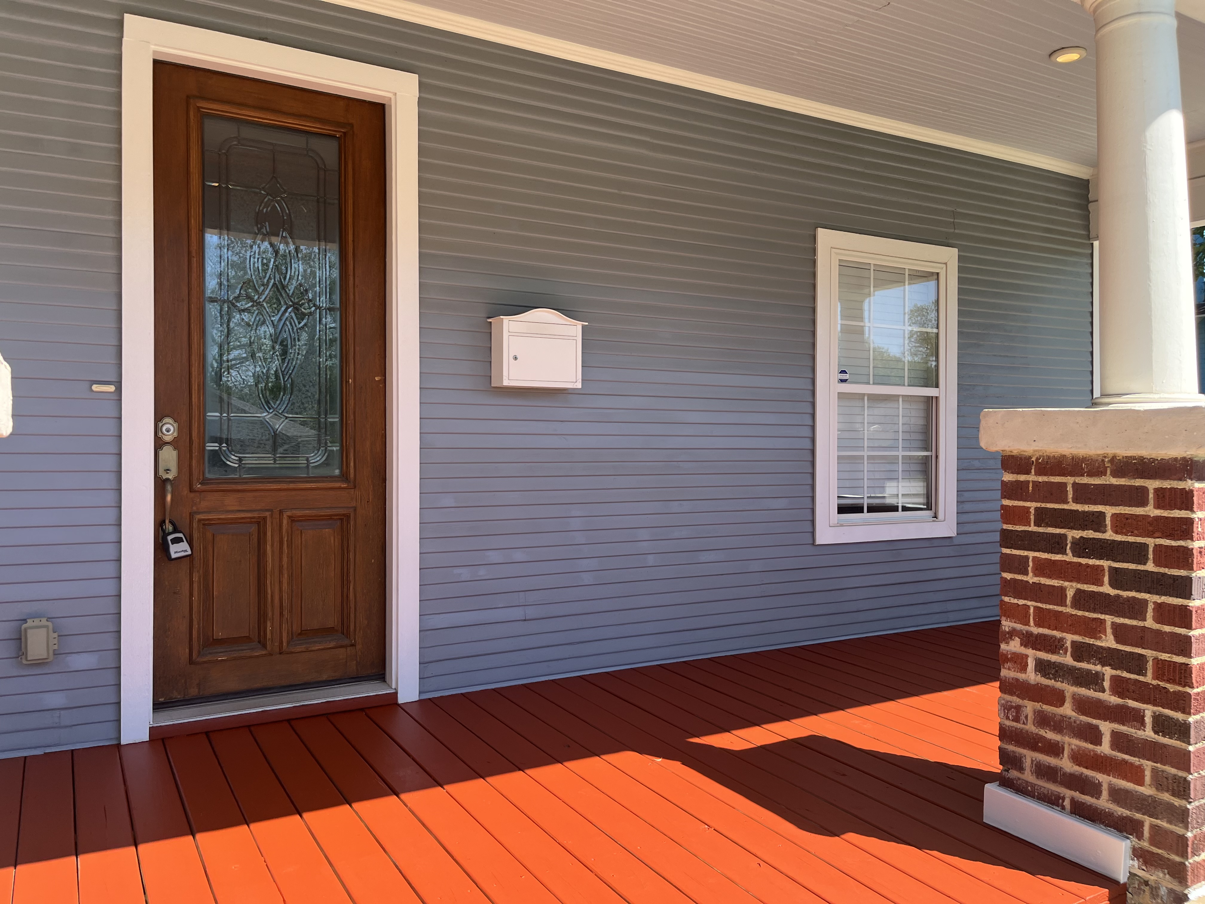 Back/side deck with painted red deck boards, metal railing system with decorative scroll accents - Angle 2