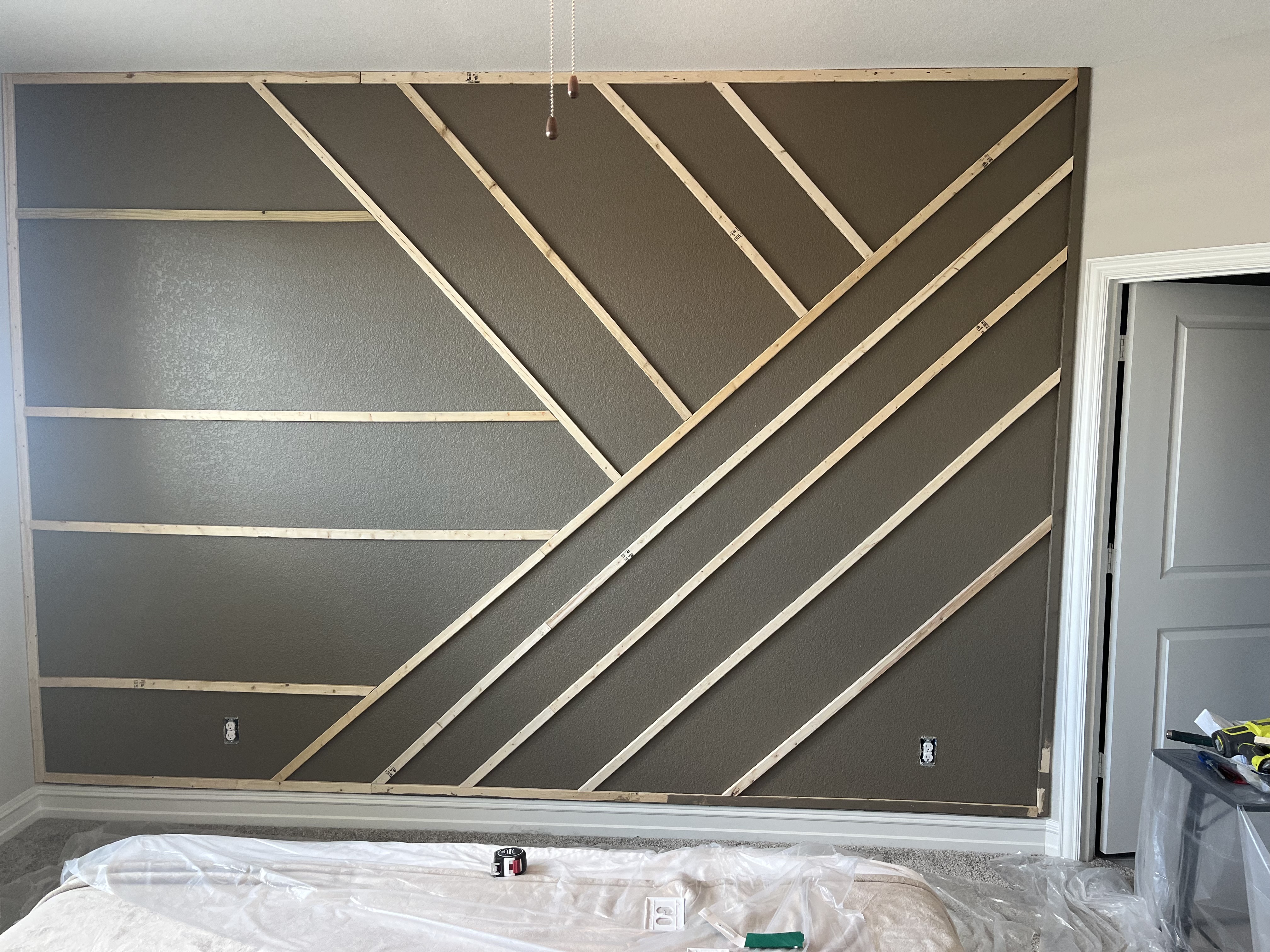 Custom accent wall framing complete - geometric wood slat design