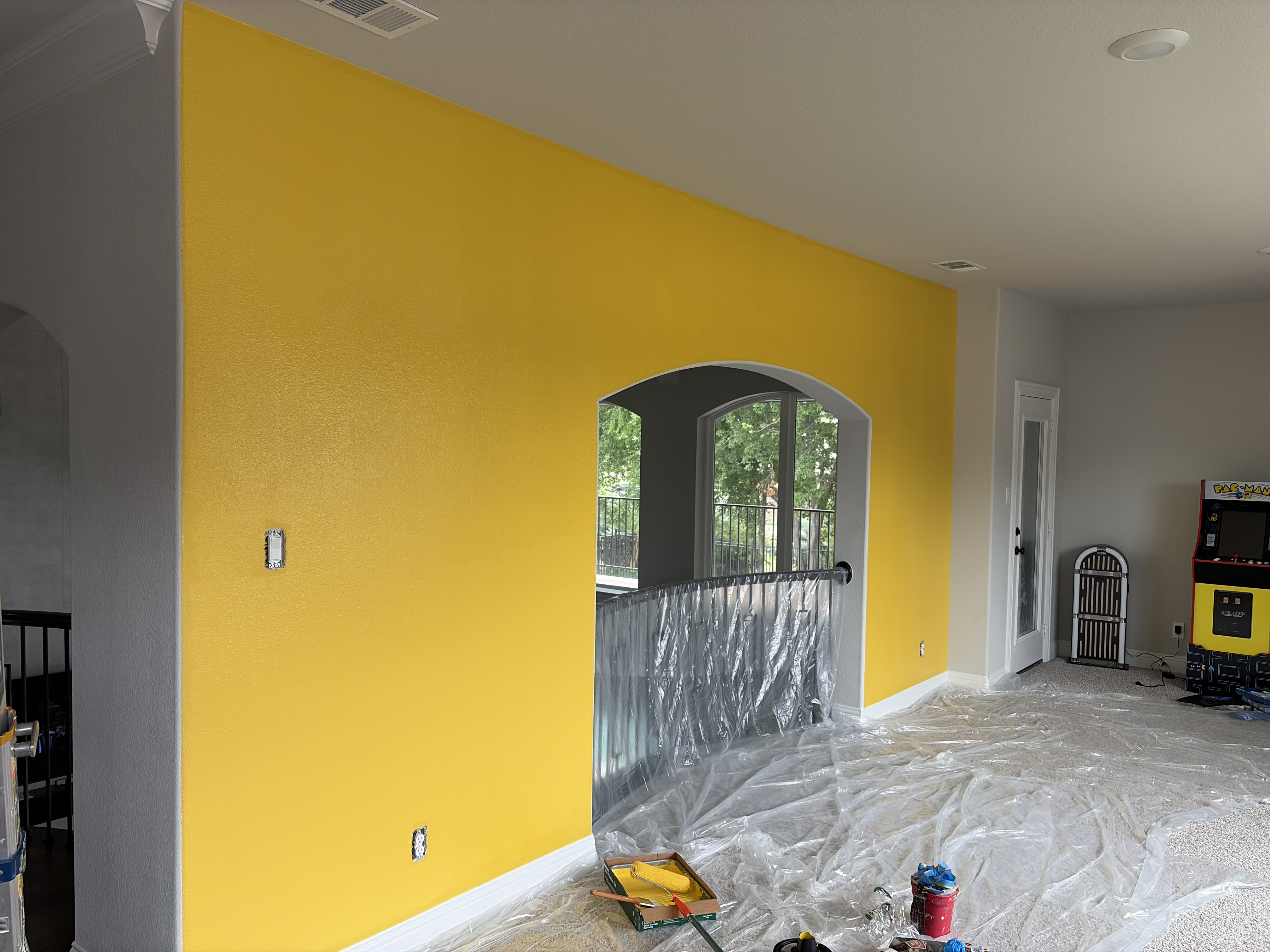 Bright yellow painted accent wall in progress