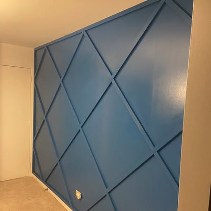 Blue diamond-pattern accent wall with painted trim detail