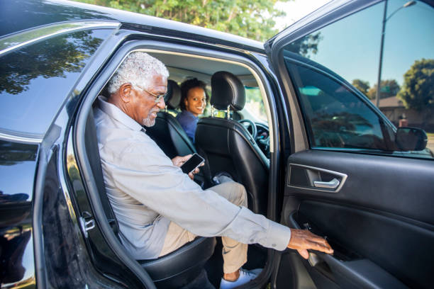Senior man receiving assistance exiting a transport vehicle