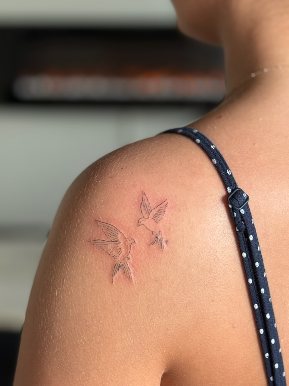 Healed fine line tattoo of two doves on shoulder