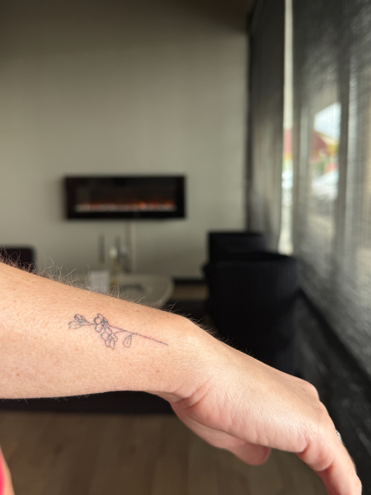 Healed delicate fine line floral branch tattoo on forearm and wrist
