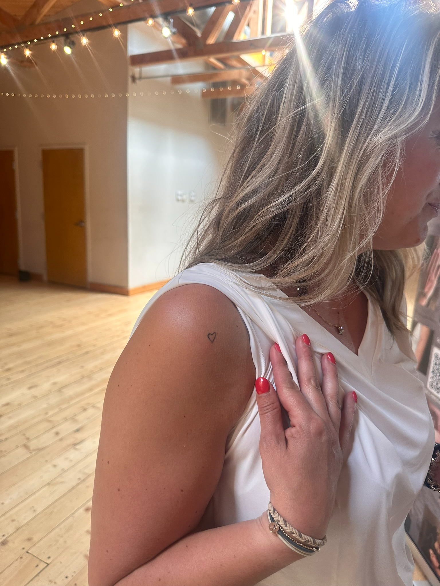 Healed fine line heart tattoo on shoulder