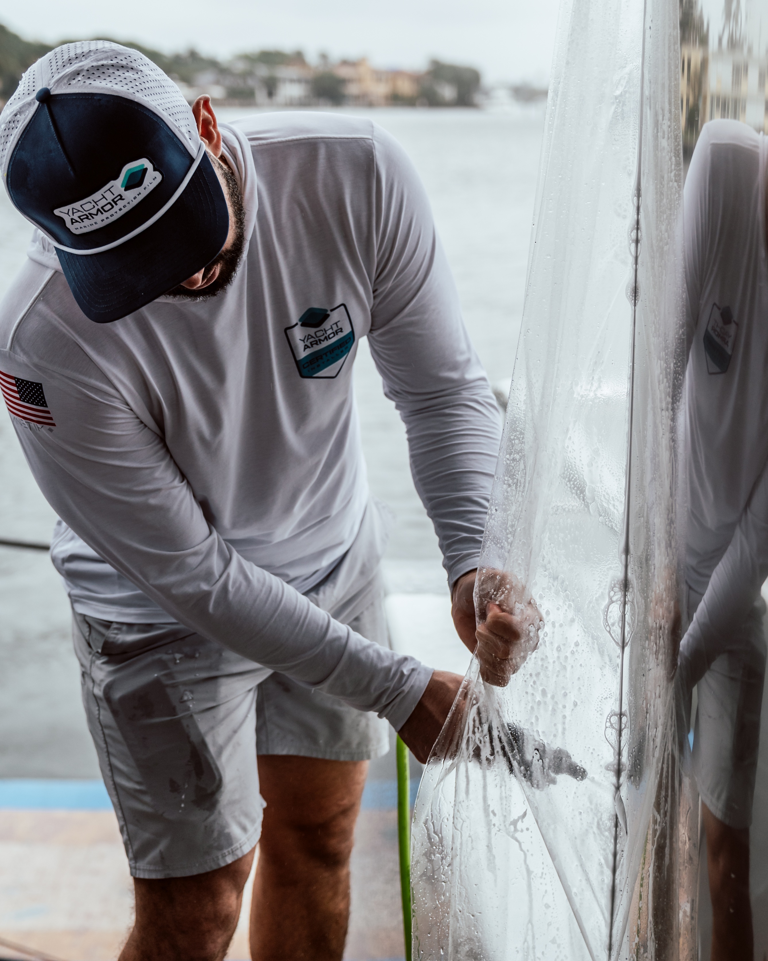 Certified Yacht Armor installer applying marine protection film to a boat hull