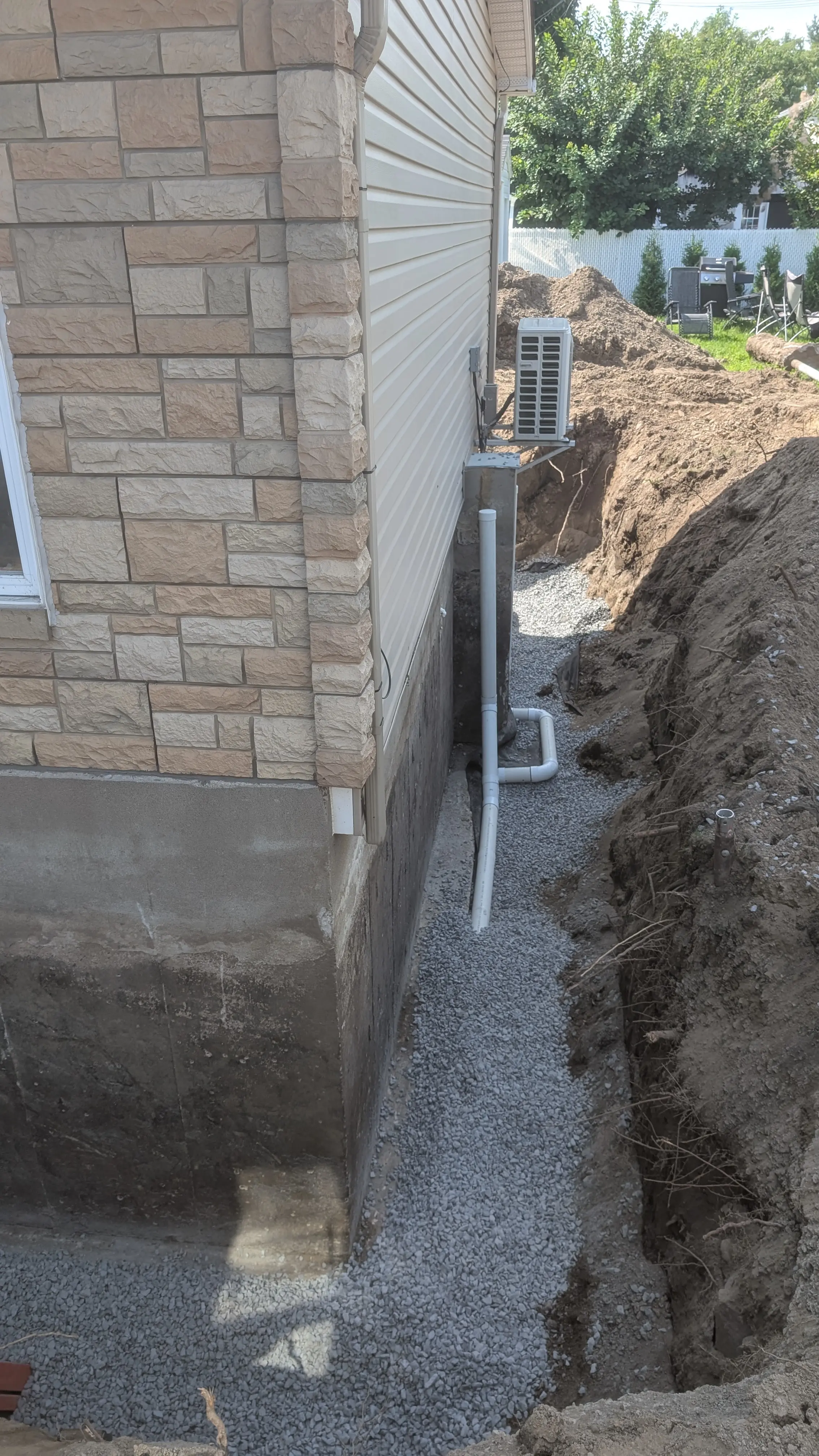 Drain français et remblaiement de pierre nette le long du mur