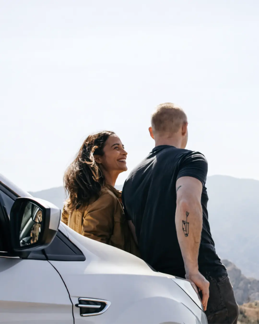 Happy couple by a car