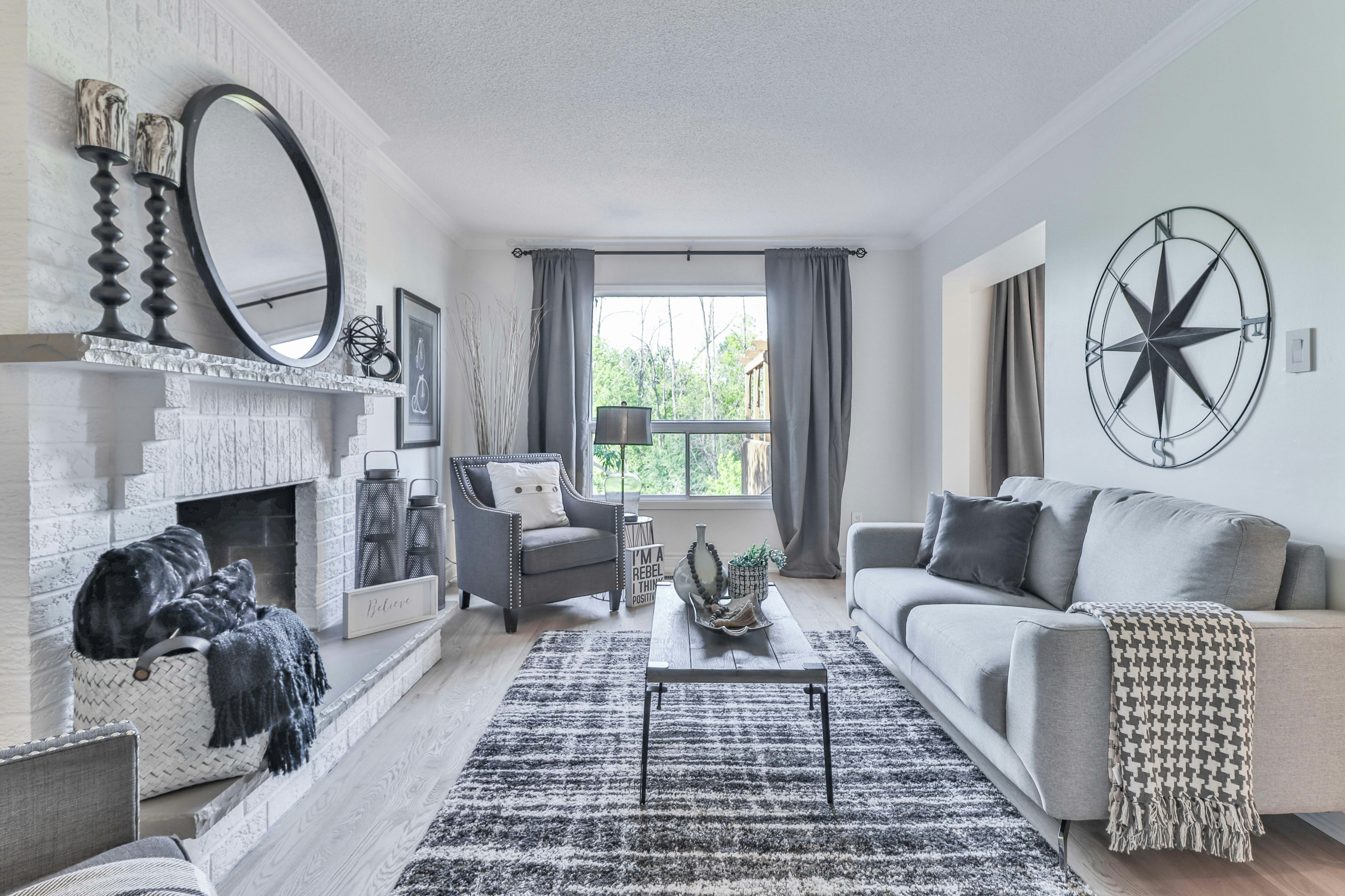 Bright living room with decorative mirror and grey sofa