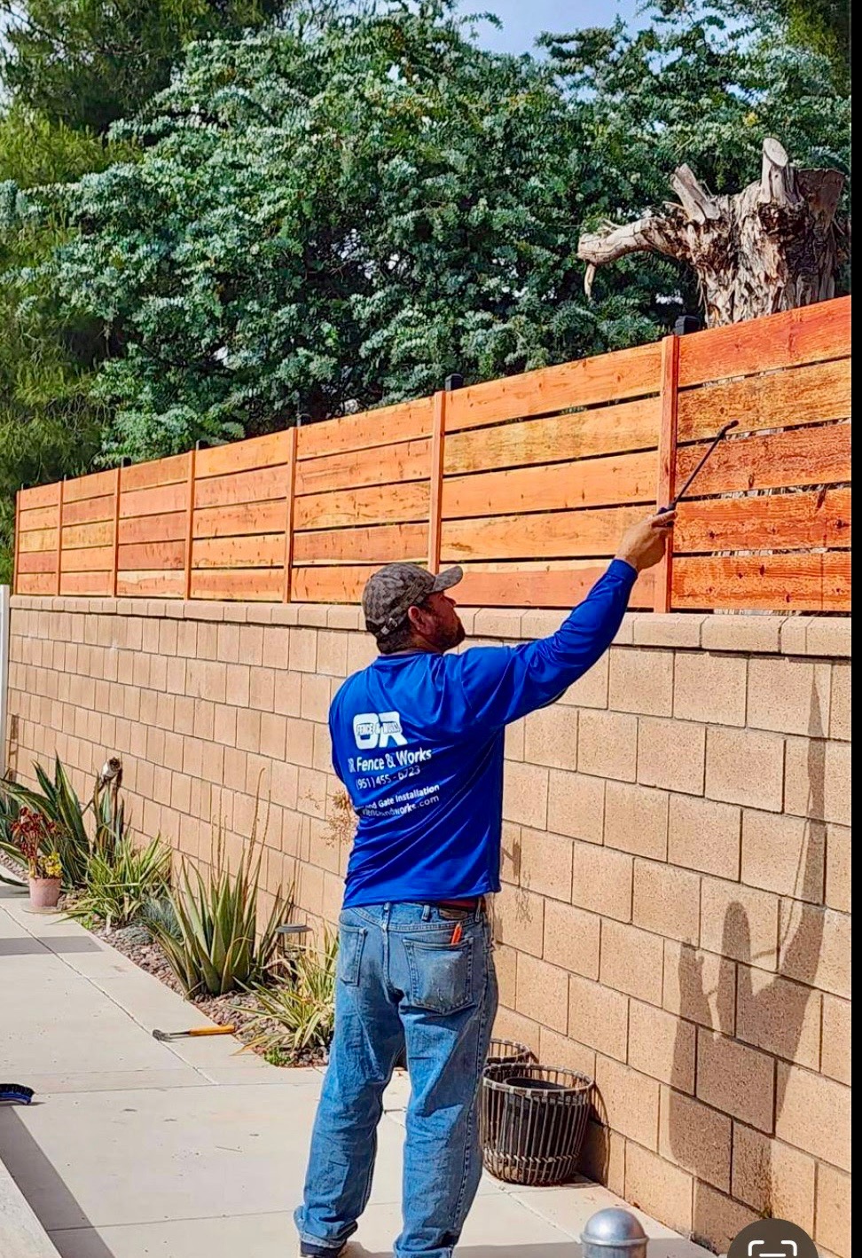 Professional fencing contractor building a wooden fence