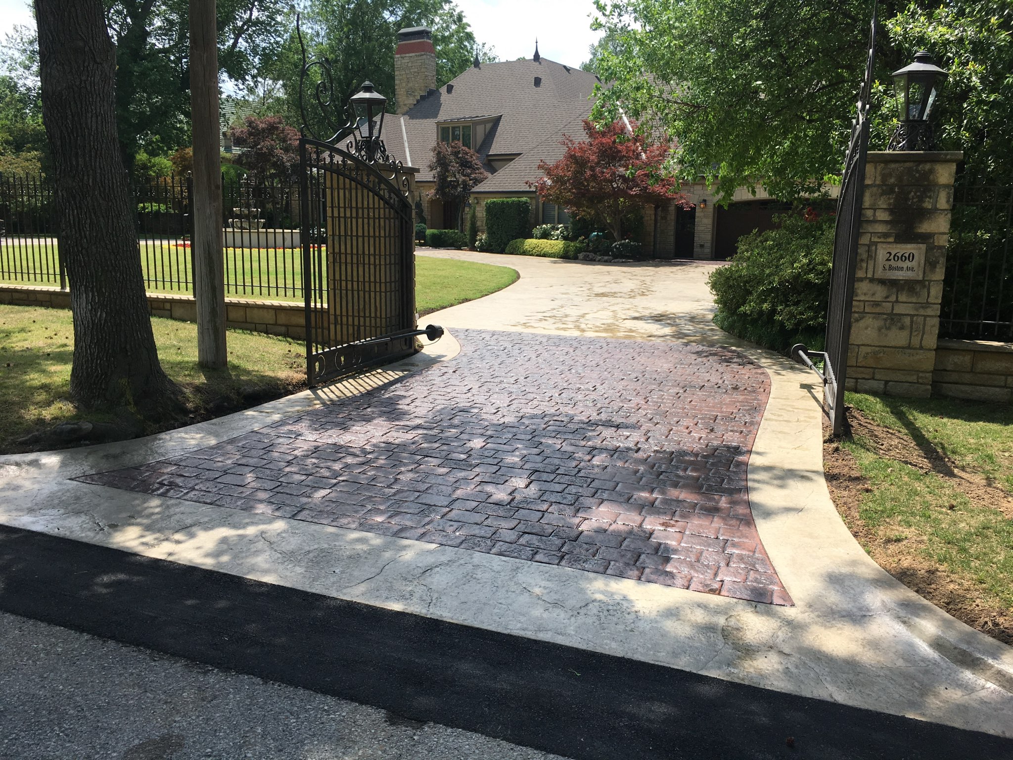 Elegant stamped concrete driveway designed with a classic brick pattern and smooth borders.