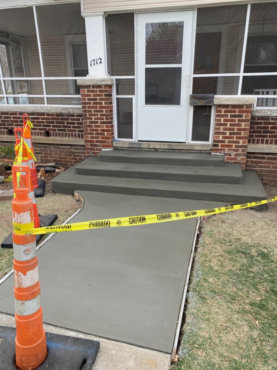 Freshly poured concrete steps and a clean, durable sidewalk leading to the front entry.