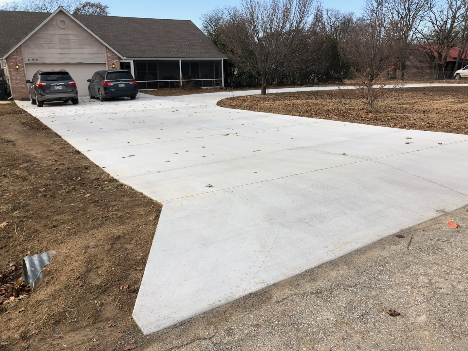 A spacious, freshly poured long circular driveway providing ample parking and smooth access.