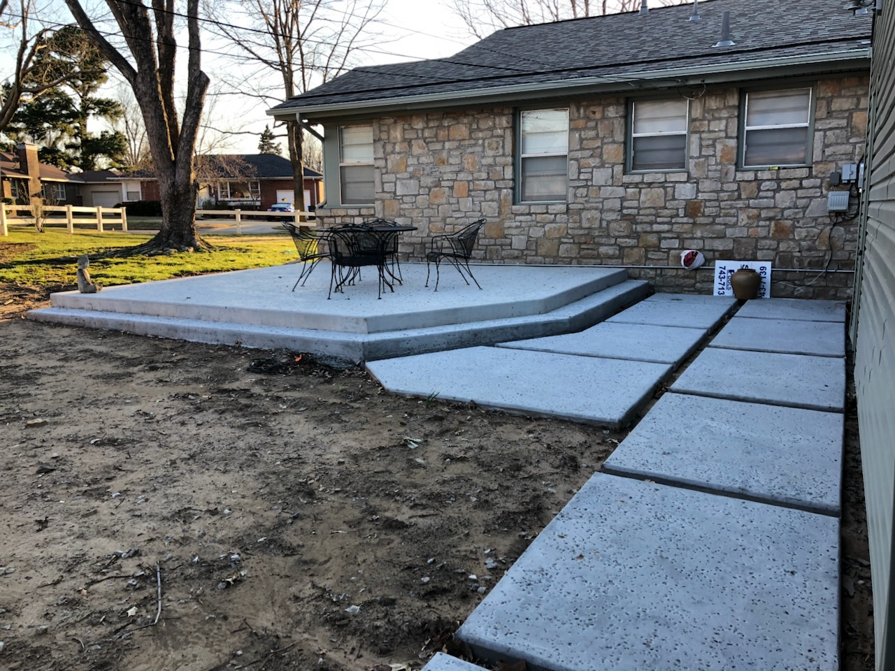 Multi-level concrete patio complete with large modern concrete stepping pads.
