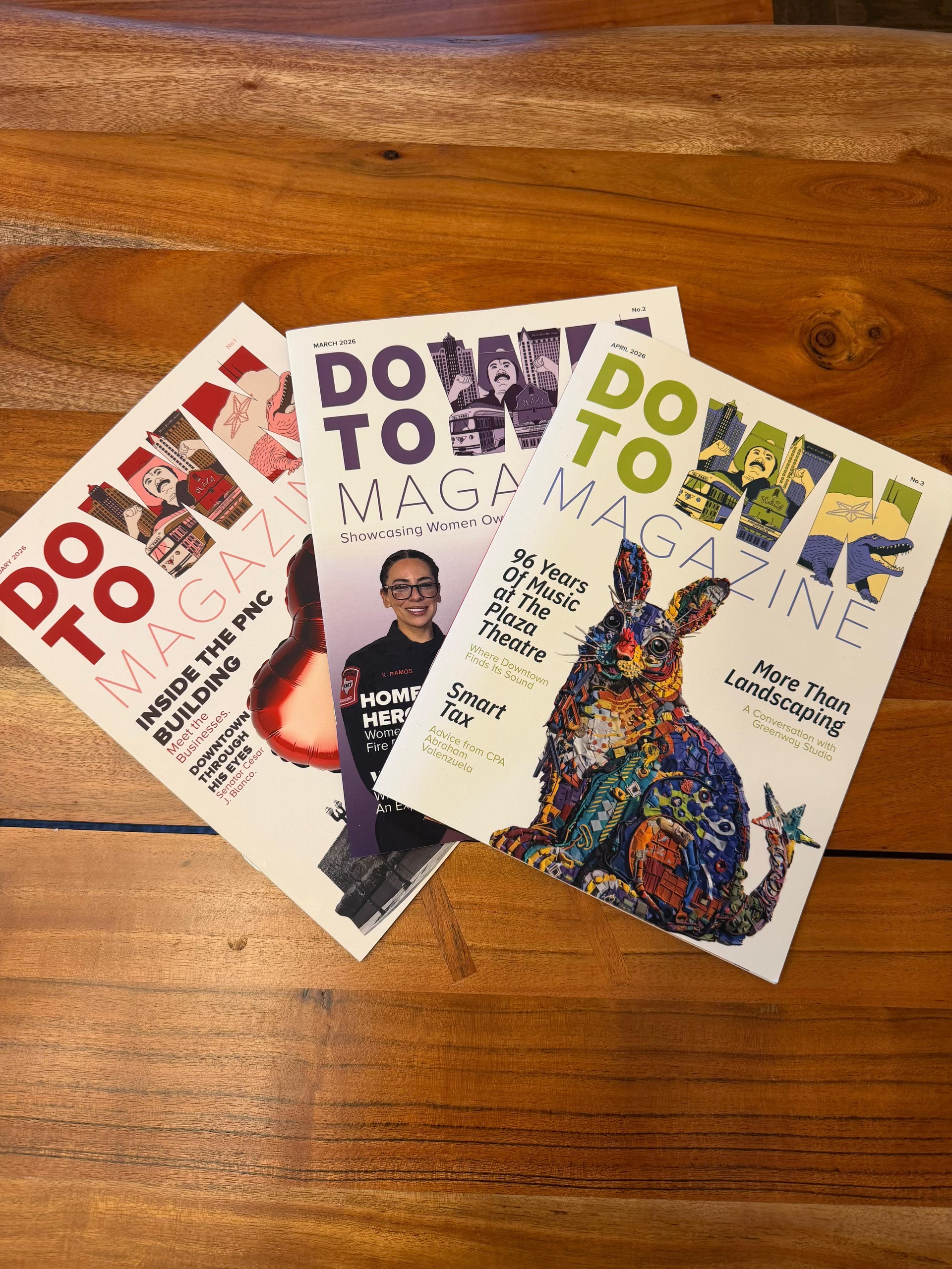Downtown Magazine issues on a wooden table