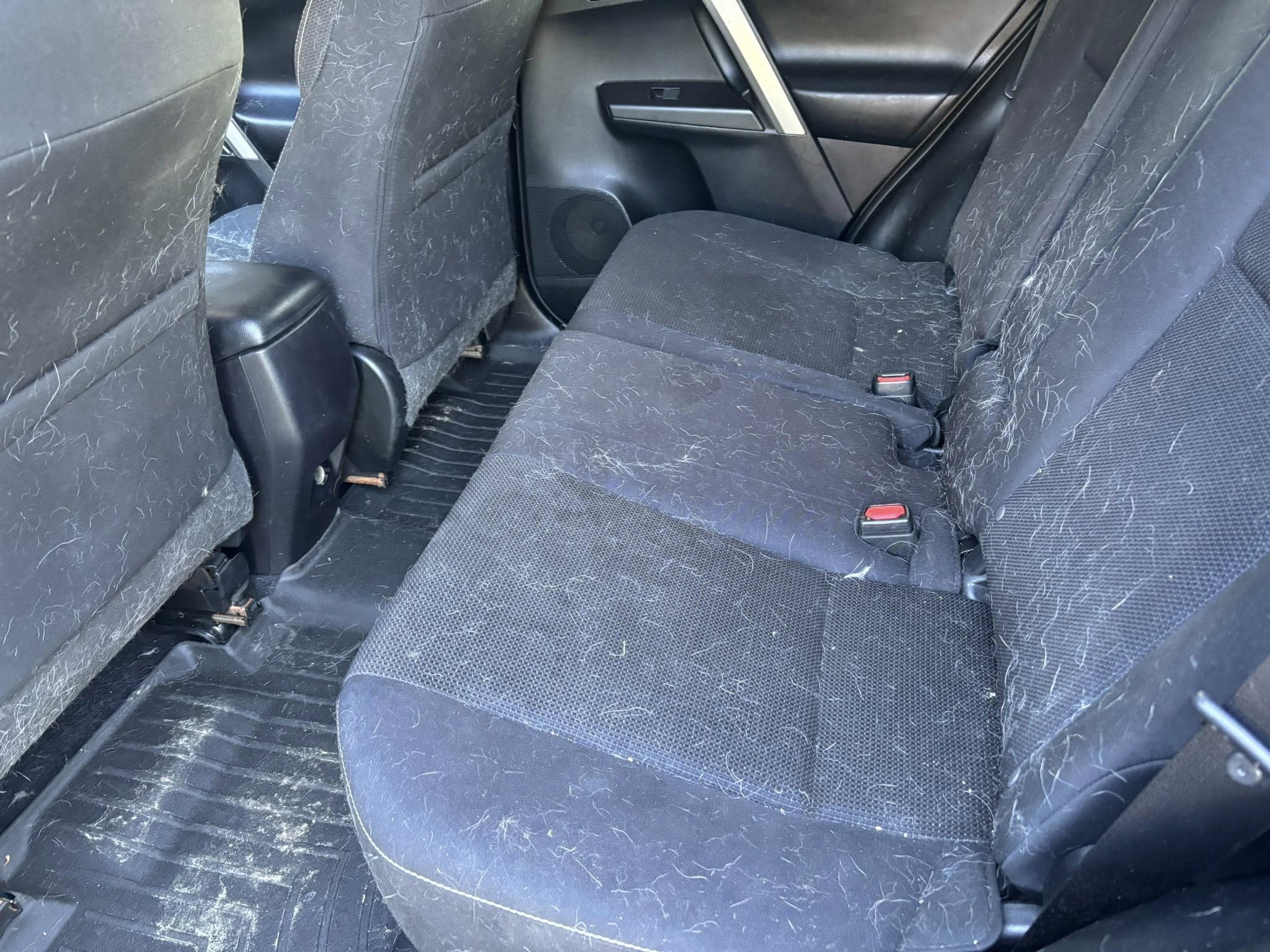 SUV rear seats covered in pet hair before interior detailing