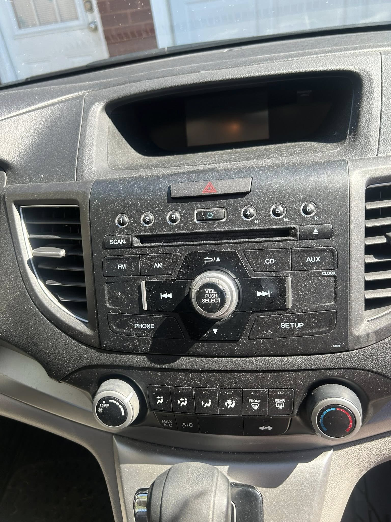 Dusty car dashboard and stereo buttons before interior detailing