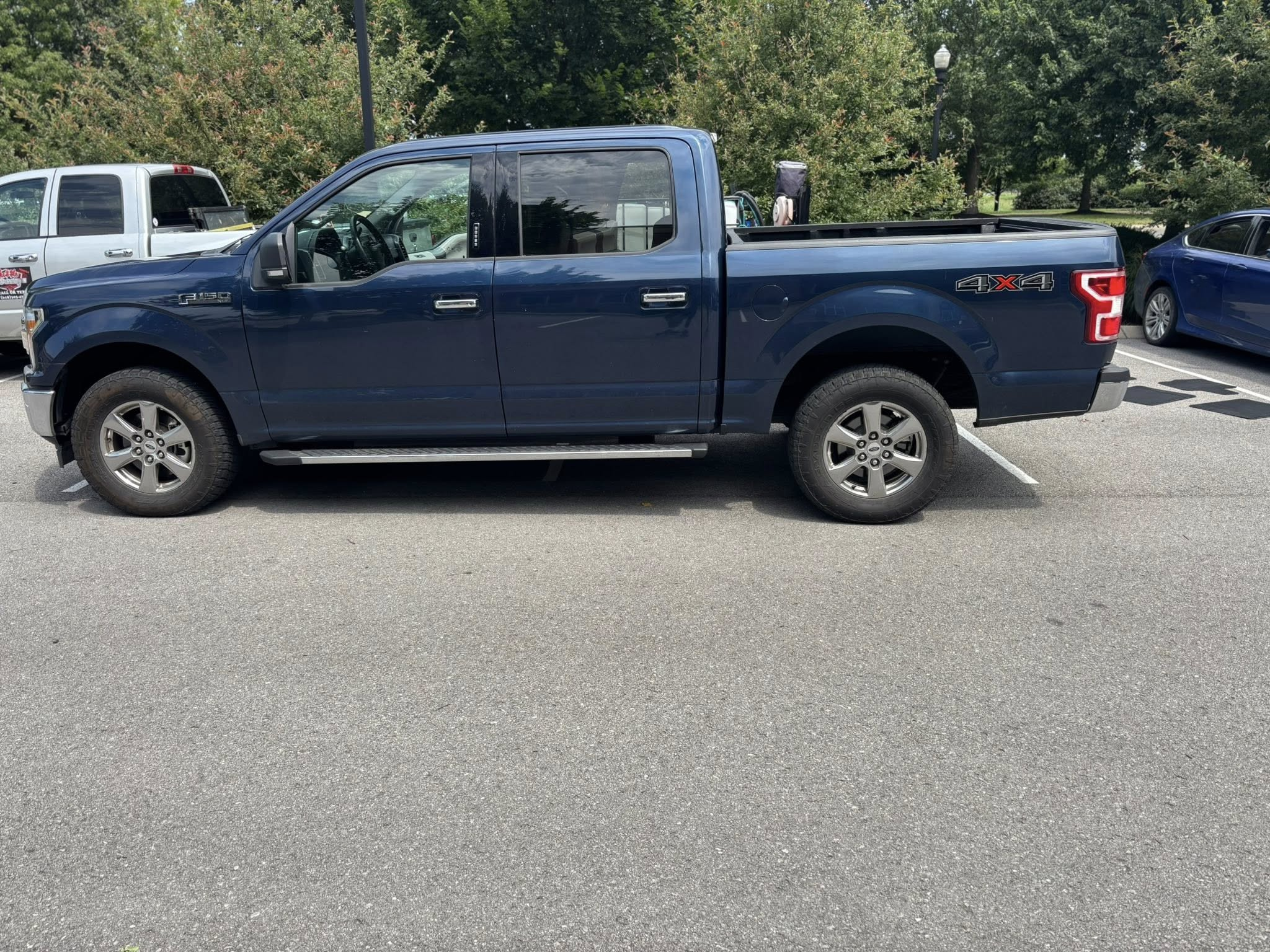 Blue Ford F-150 truck side profile before exterior wash and detail
