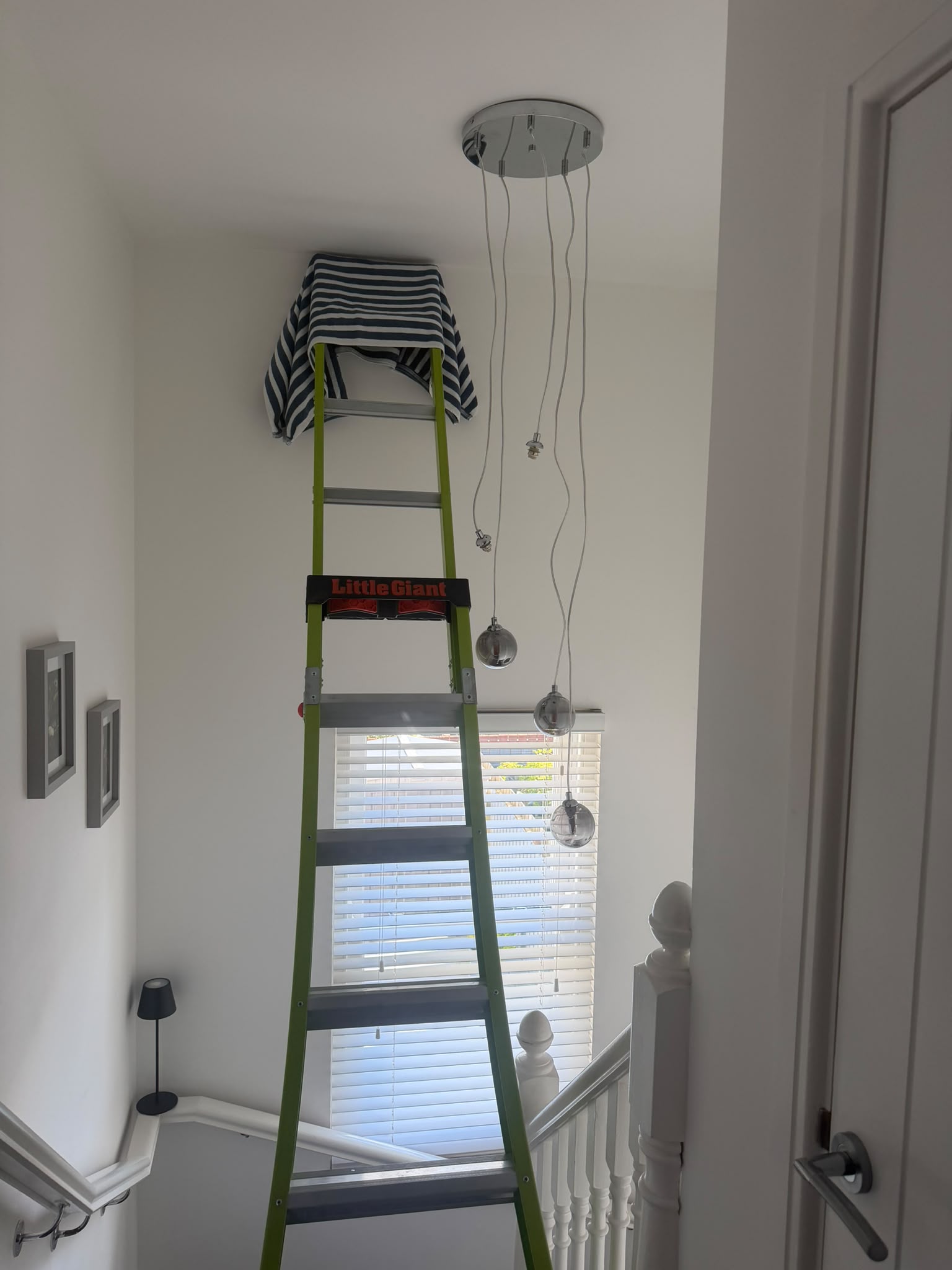 Careful stairwell ladder setup with wall protection