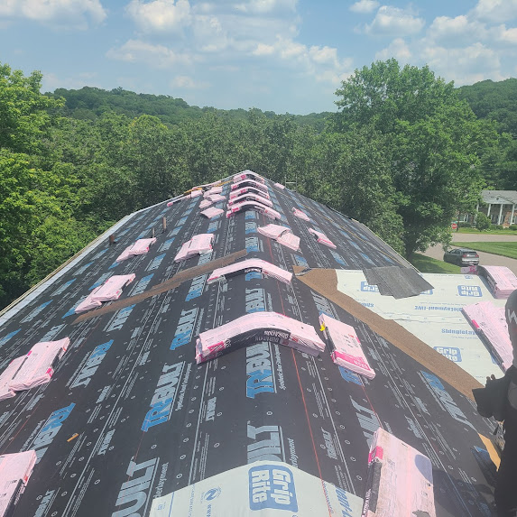 Roof deck covered with premium synthetic underlayment and shingle bundles staged for installation by Worth Roofing Company