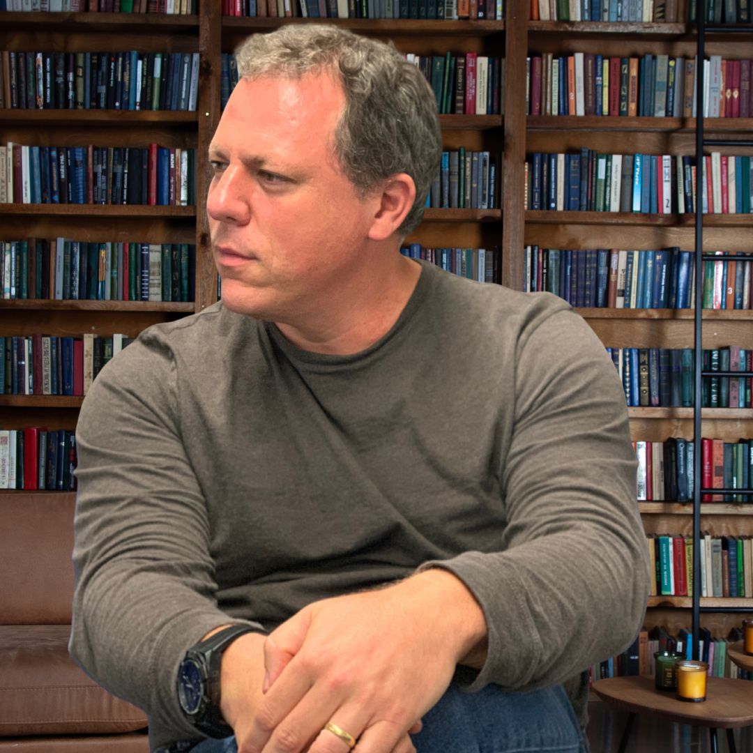 Dan Grech sitting in front of a bookshelf
