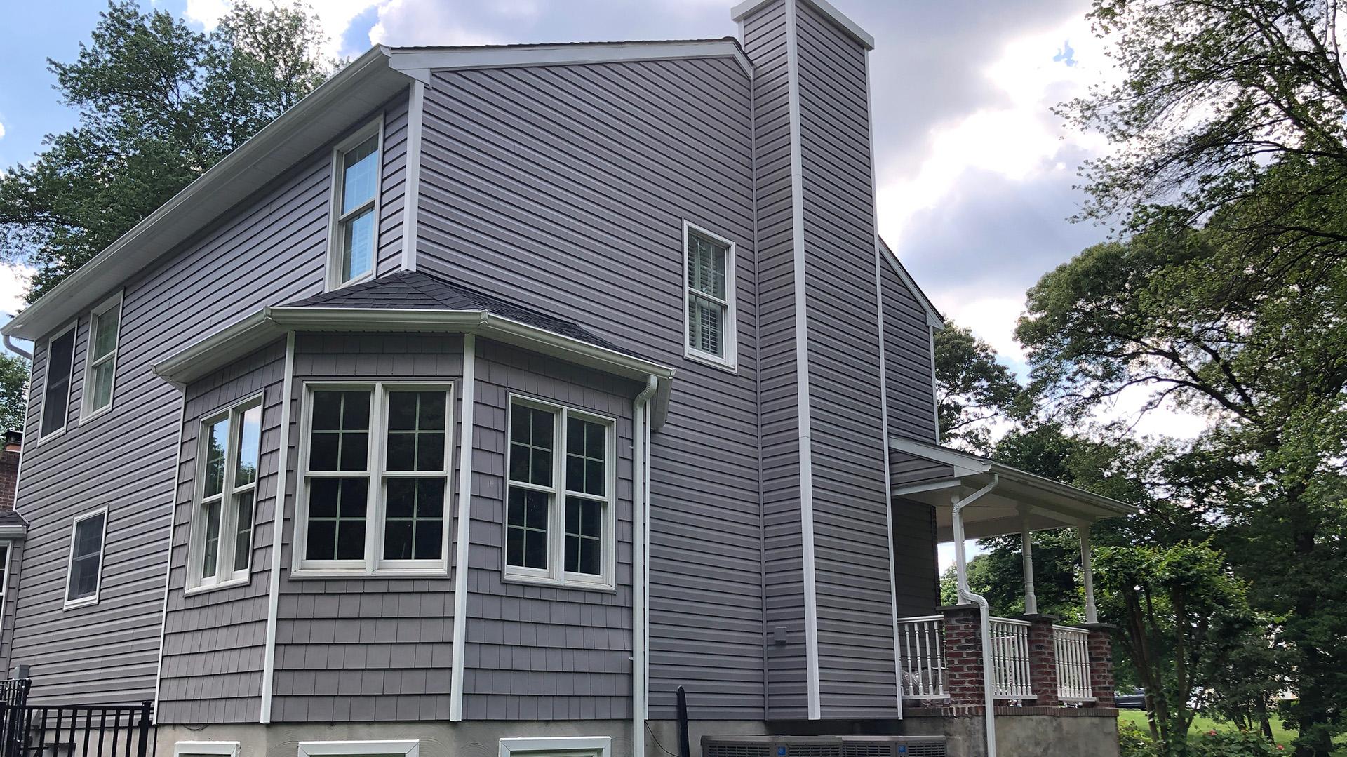 Gray Siding Installation - Complete exterior update featuring premium gray siding and crisp white trim.