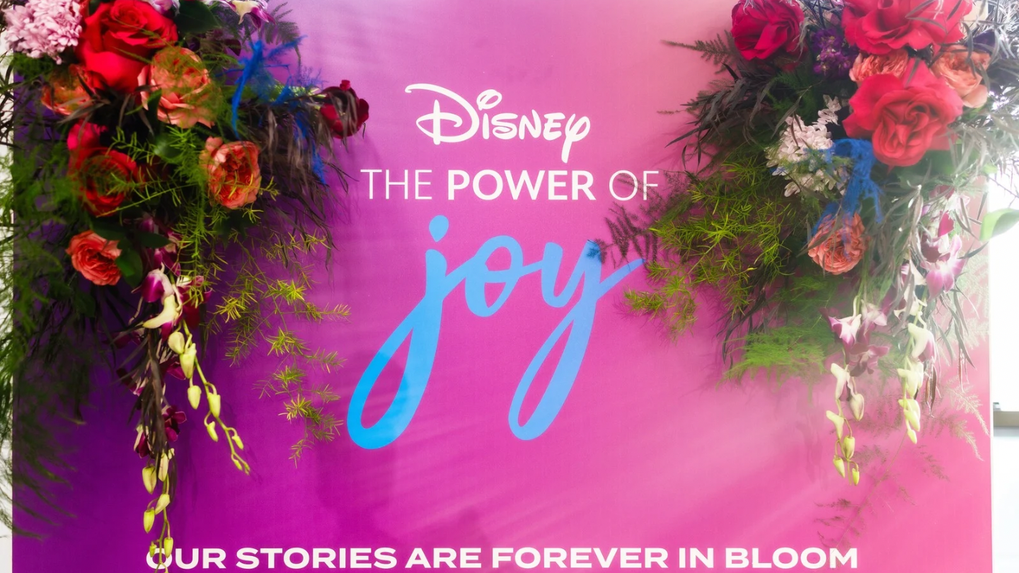 Disney The Power of Joy branded floral photo backdrop activation