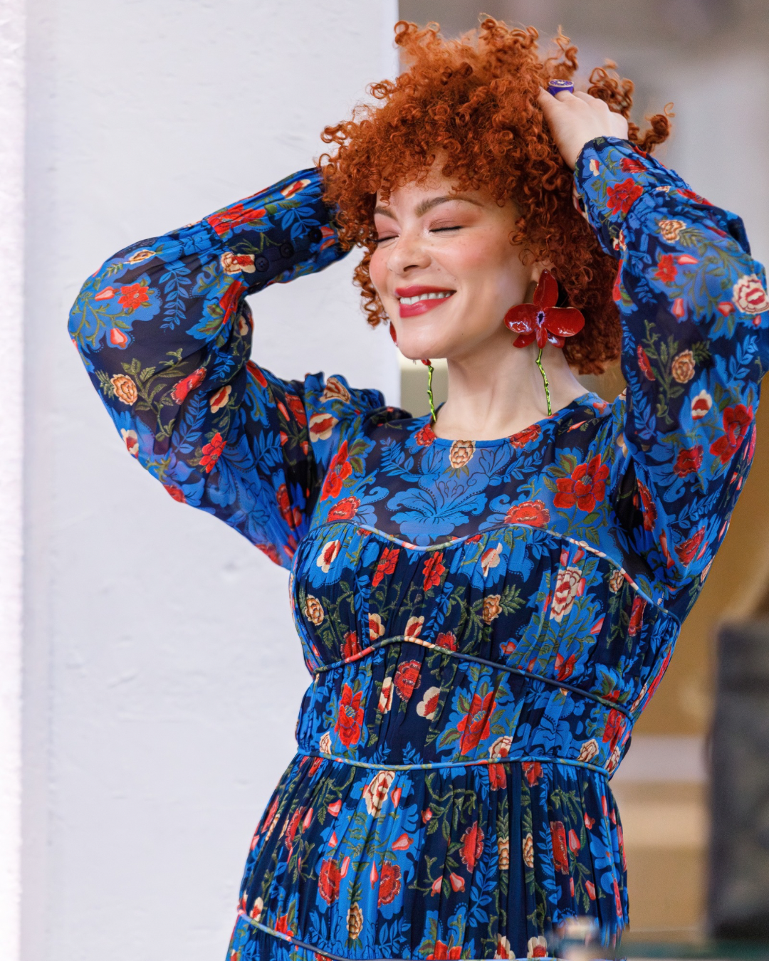 Joyful guest portrait in vibrant floral dress at brand activation