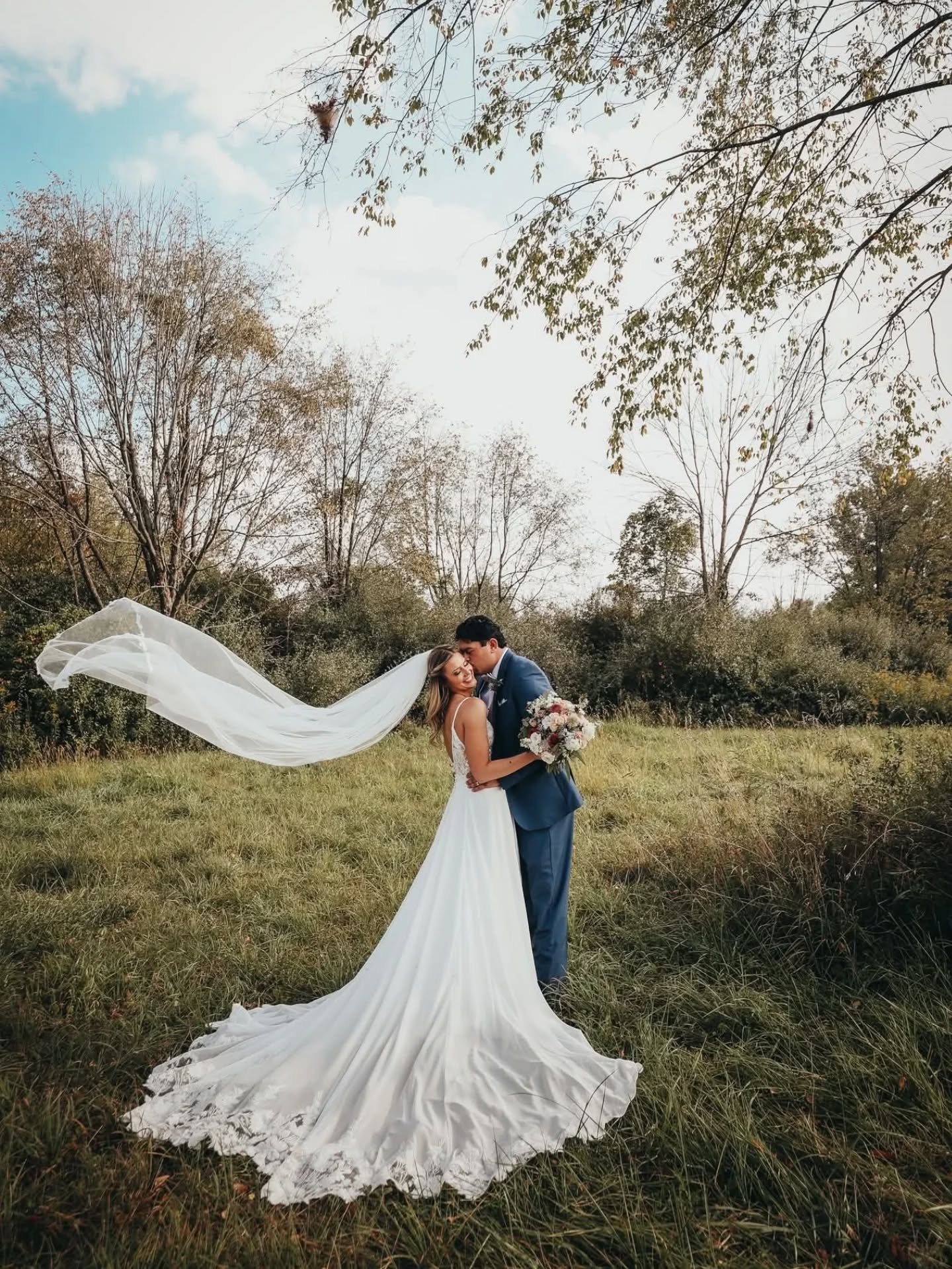 Bride with flowing veil in field