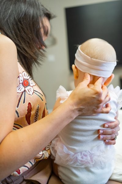 Dr. Liz gently assessing an infant's neck and head movement