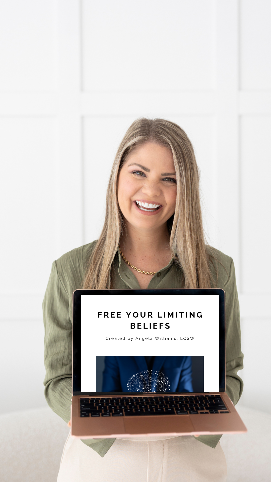 Angela holding laptop with Free Your Limiting Beliefs course