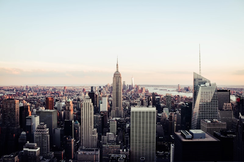 Empire State Building towering over New York City skyline at sunset, showcasing urban architecture and city life.