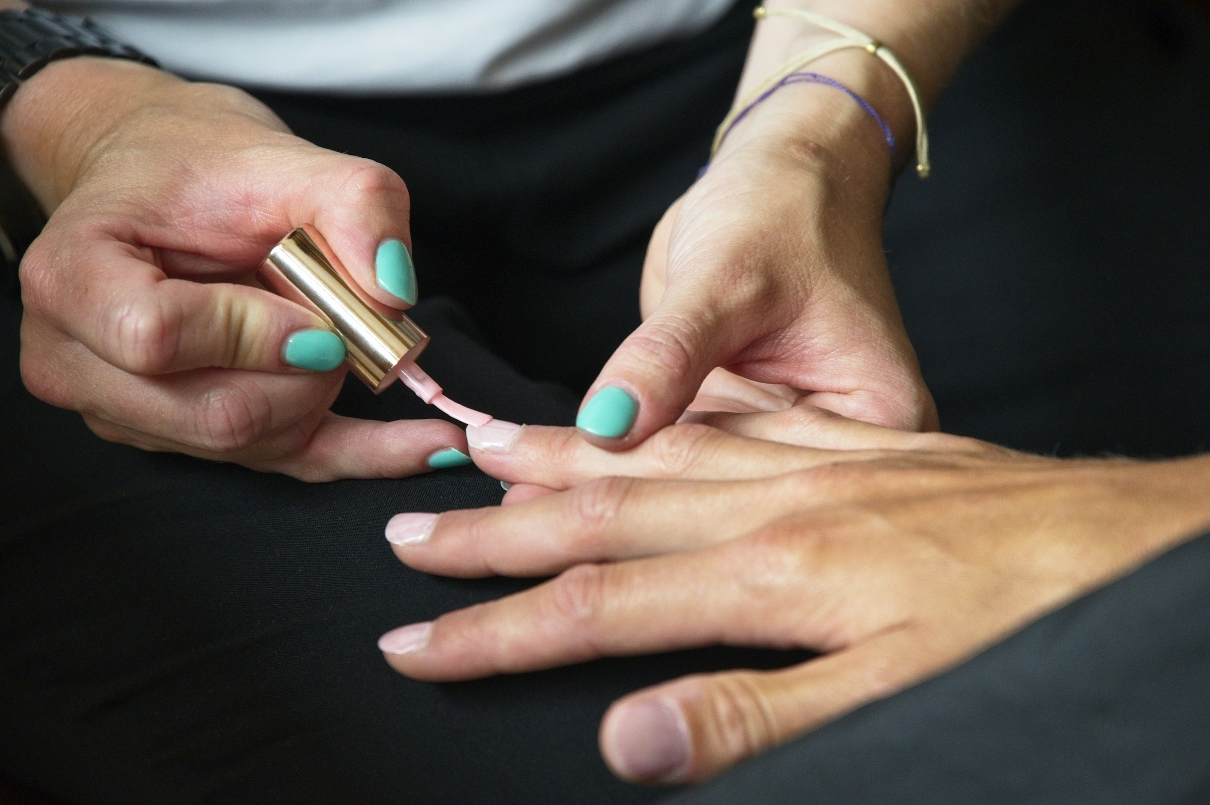 Nail technician applying sheer nude gel polish to a client's hand — boutique nail appointment at Arden Nail Studio, Greenville SC