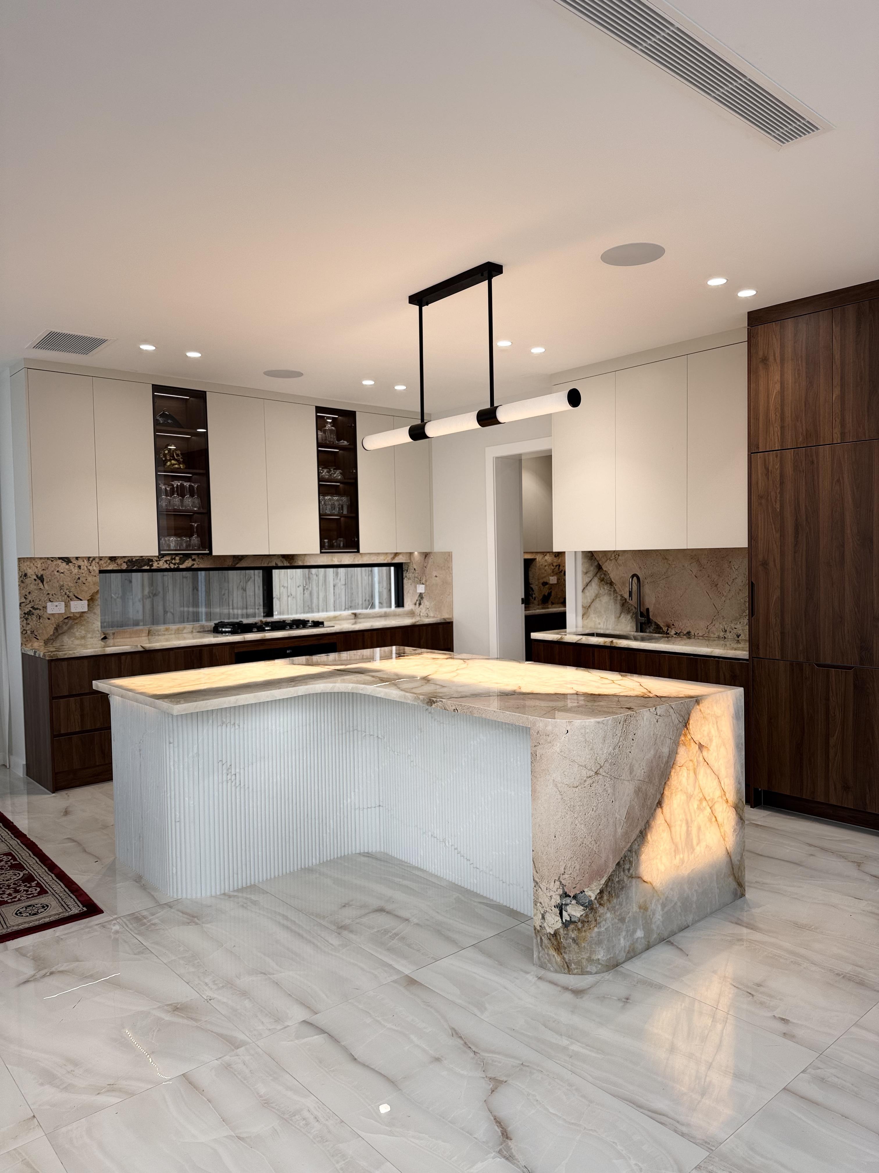 Luxury backlit marble kitchen island with walnut cabinetry, premium stone protection film by Pro Surface Protection