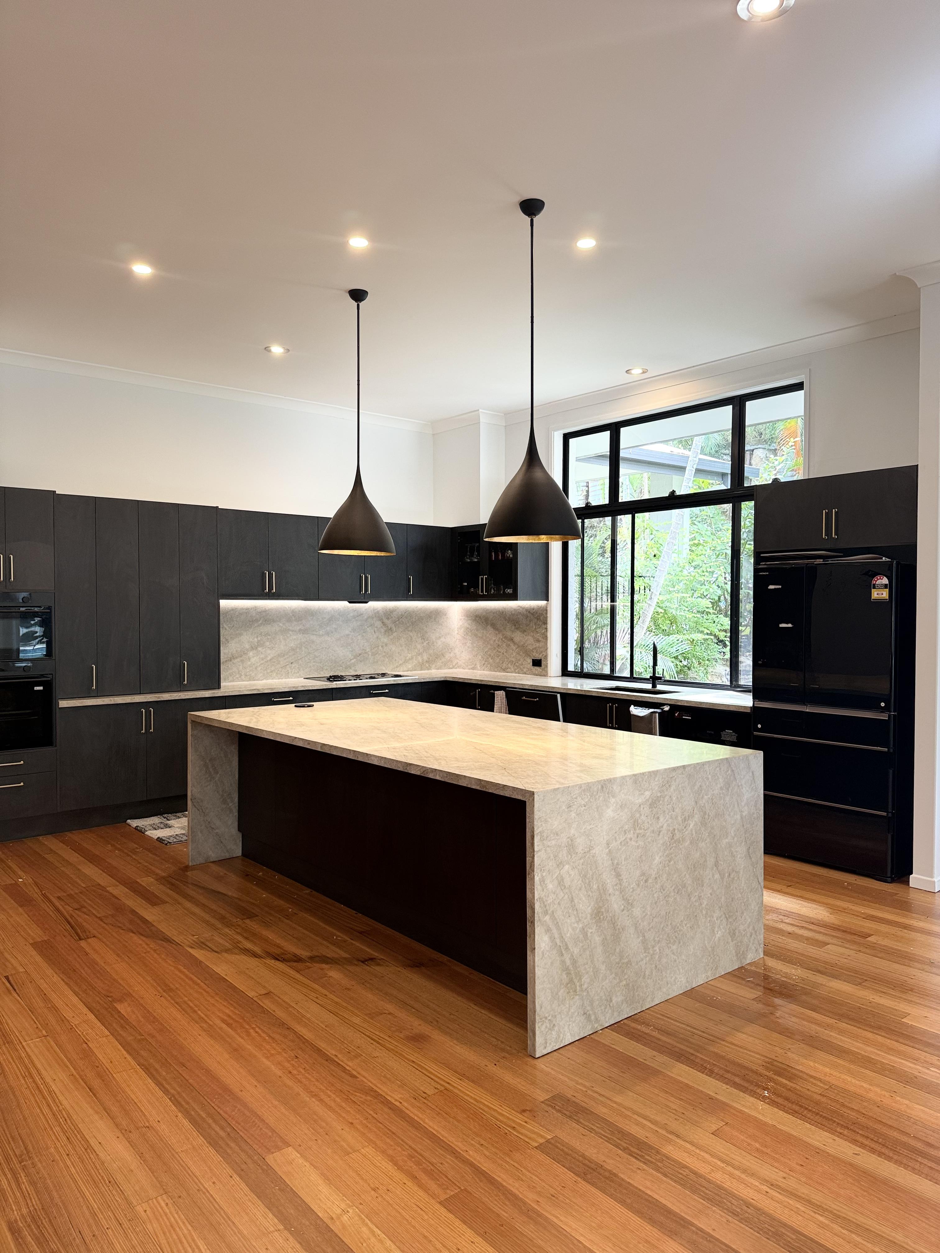 Contemporary dark kitchen with stone benchtop protection film applied by Pro Surface Protection