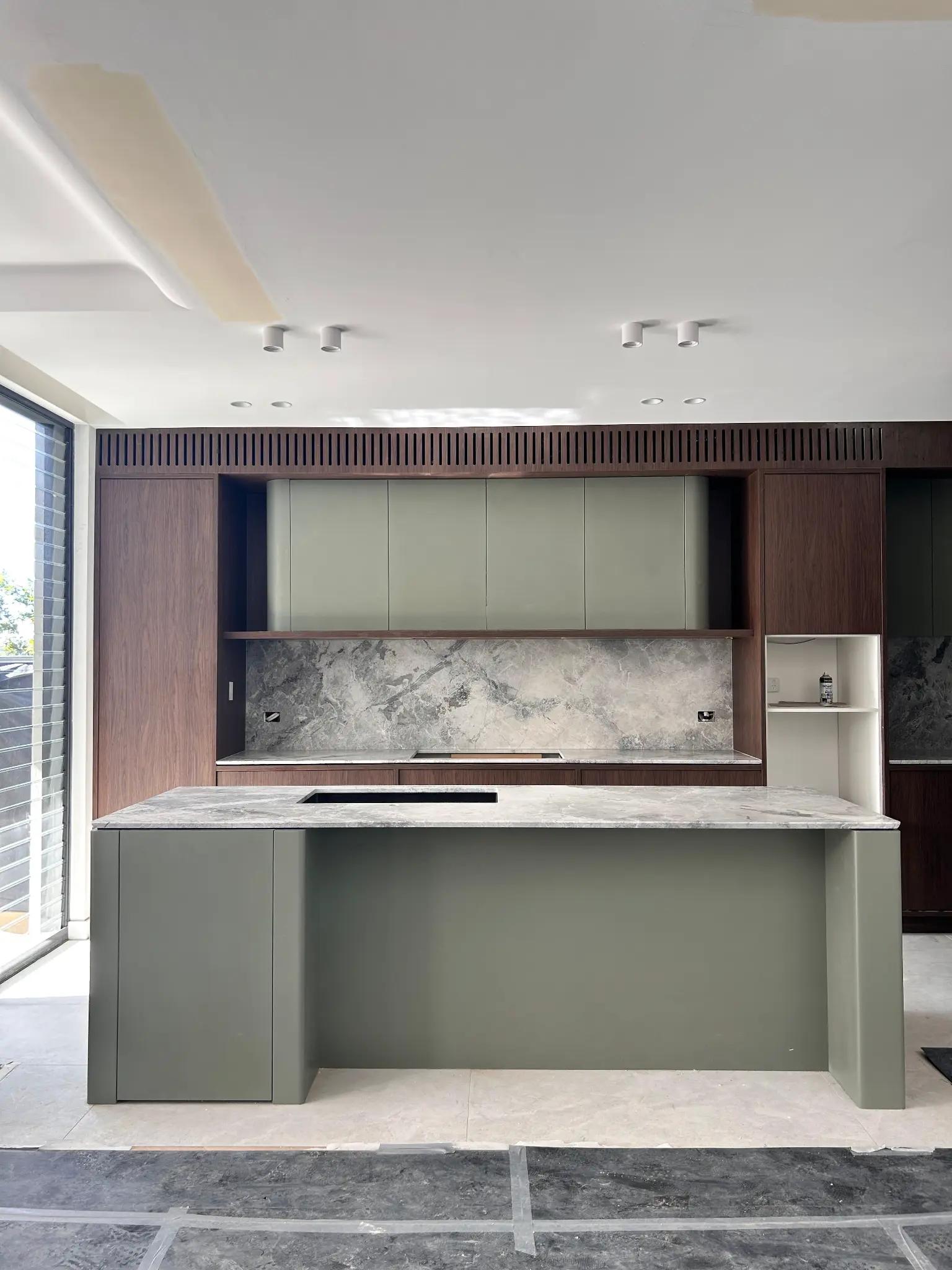 Modern kitchen with sage green cabinetry and marble island, stone protection film by Pro Surface Protection Sydney