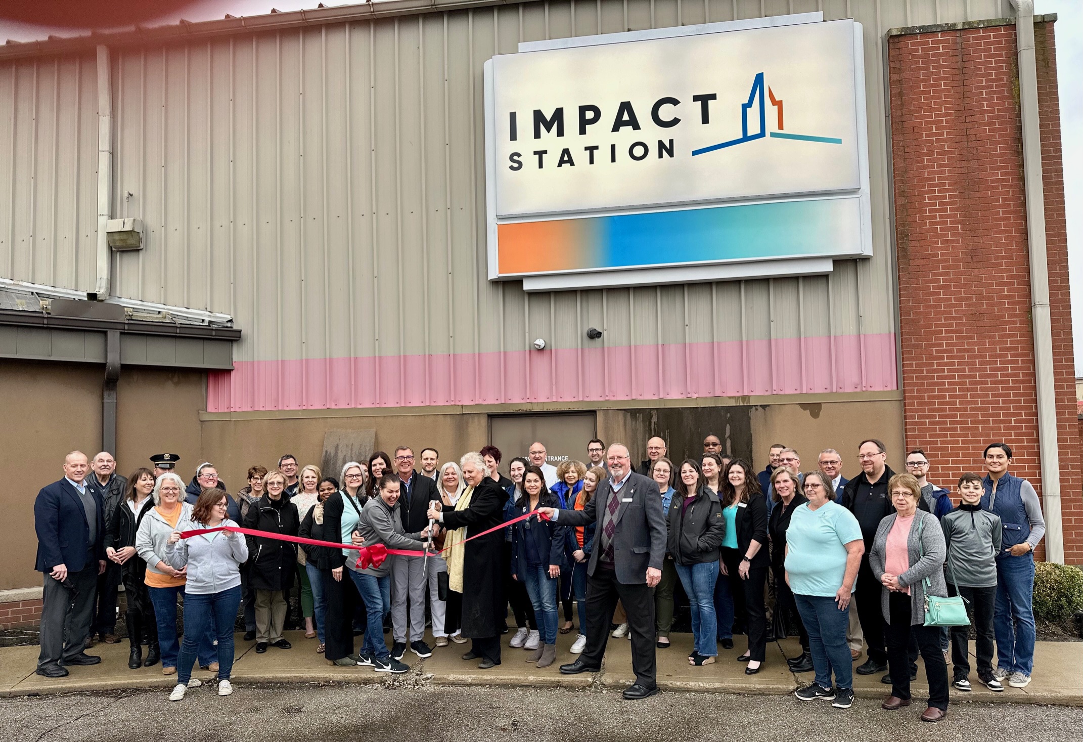 Impact Station ribbon cutting ceremony with volunteers and community members
