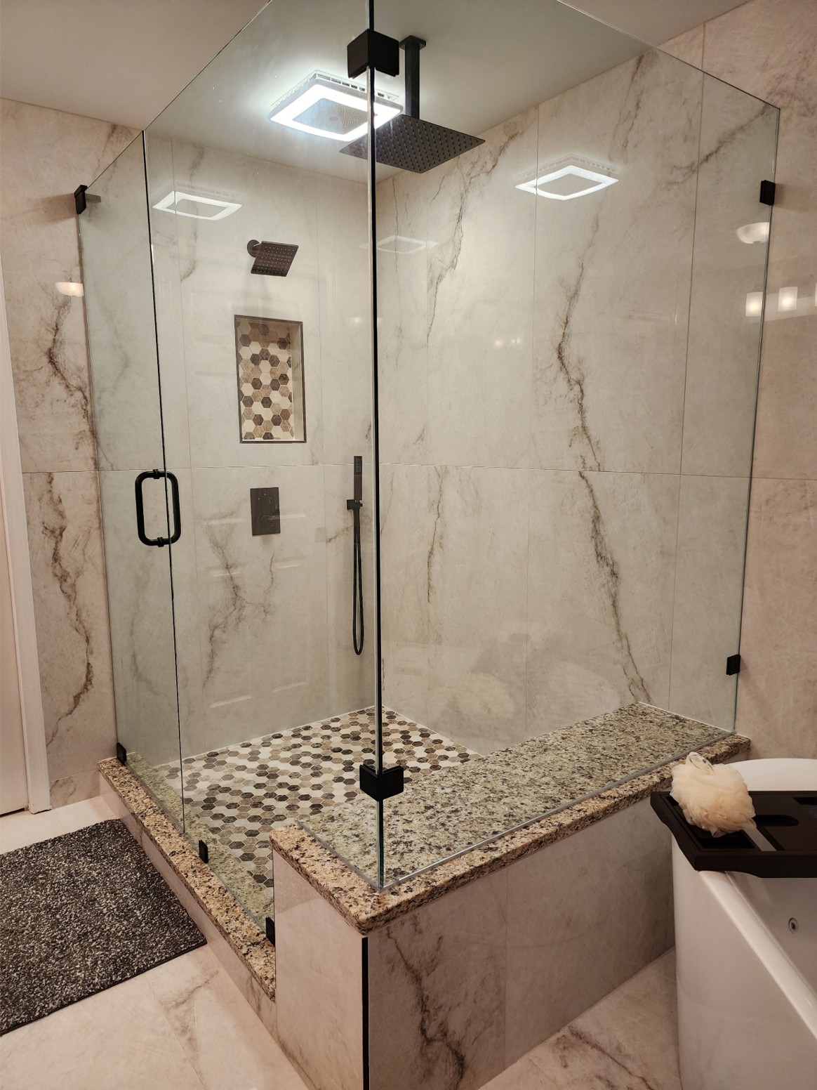Frameless glass shower with marble tile and granite bench Cartersville GA — Marshall's Handyman Service
