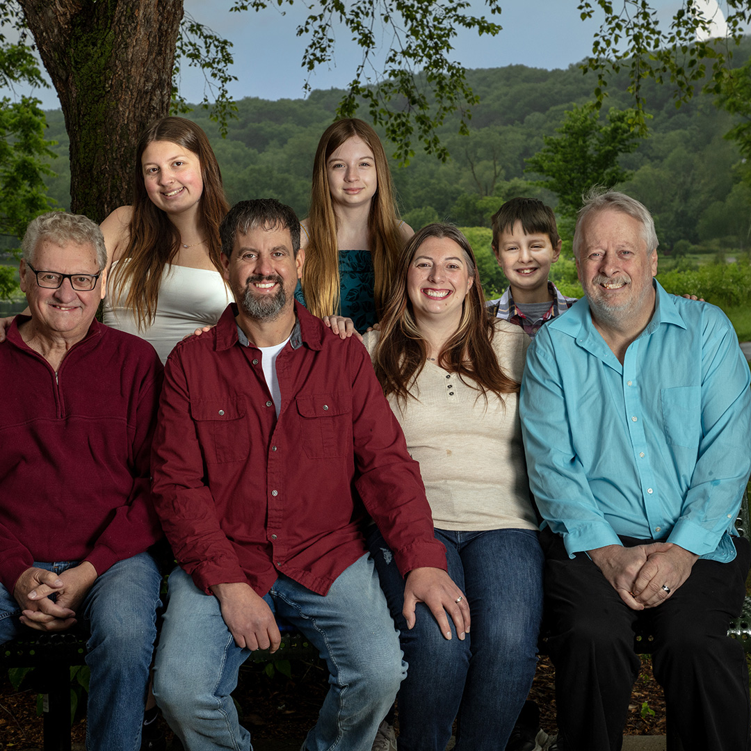 Large family group sitting on a park bench