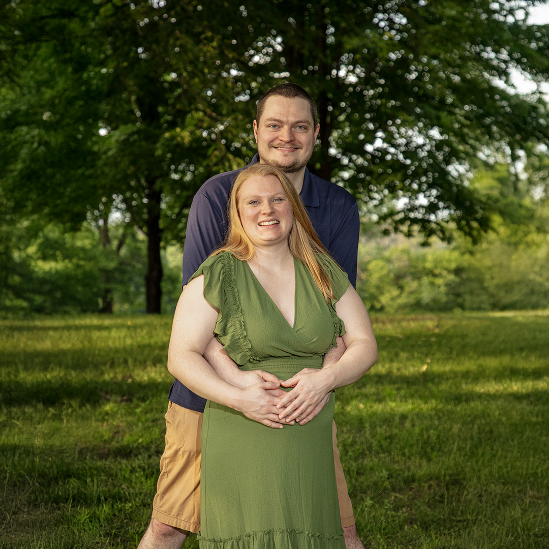 Expecting couple standing in a park