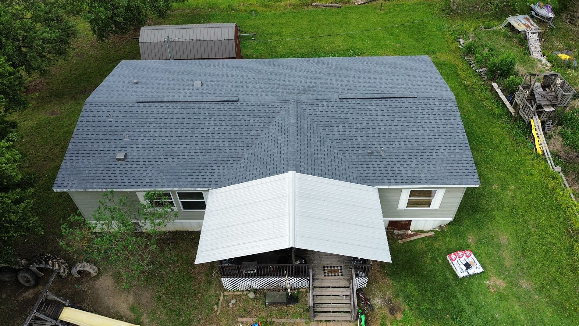 Aerial view of residential roof with white metal porch section